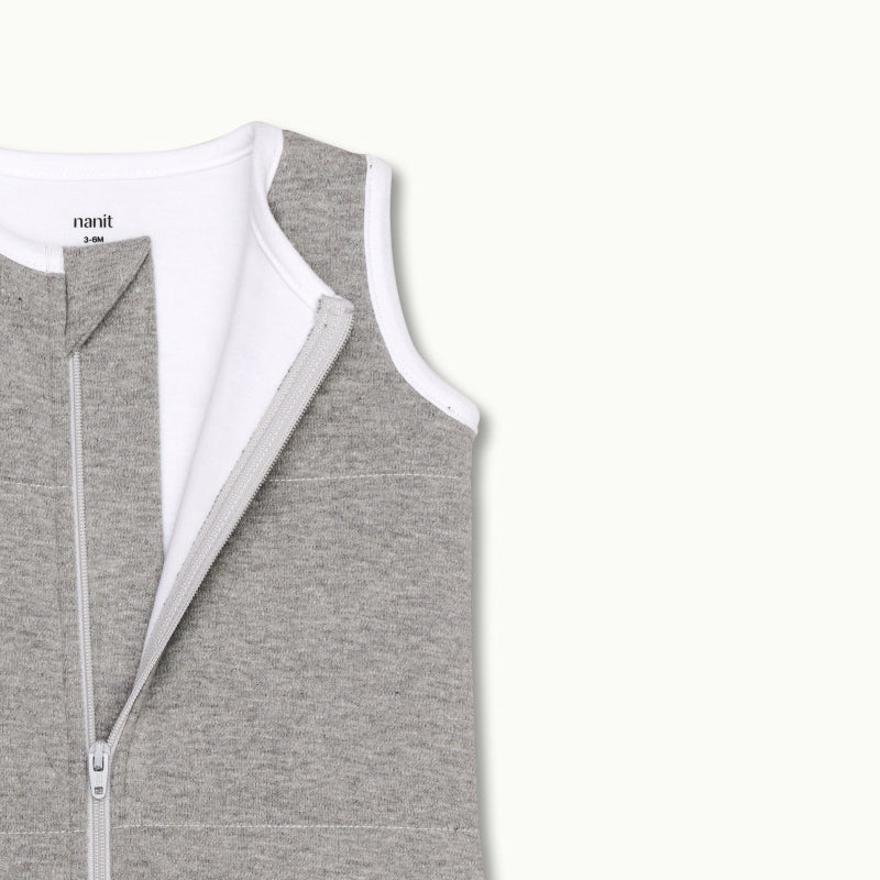 zoomed in on nickel-free snap tab zipper cover, plus protective chin zipper guard on sleeping bag in heather gray