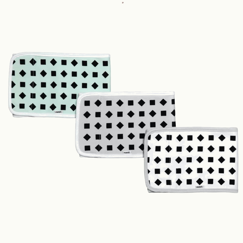 Three folded rectangular cloths with black geometric patternsβsquares and diamondsβon white or light mint backgrounds, each bordered with white trim, arranged in a staggered row. #multicolor