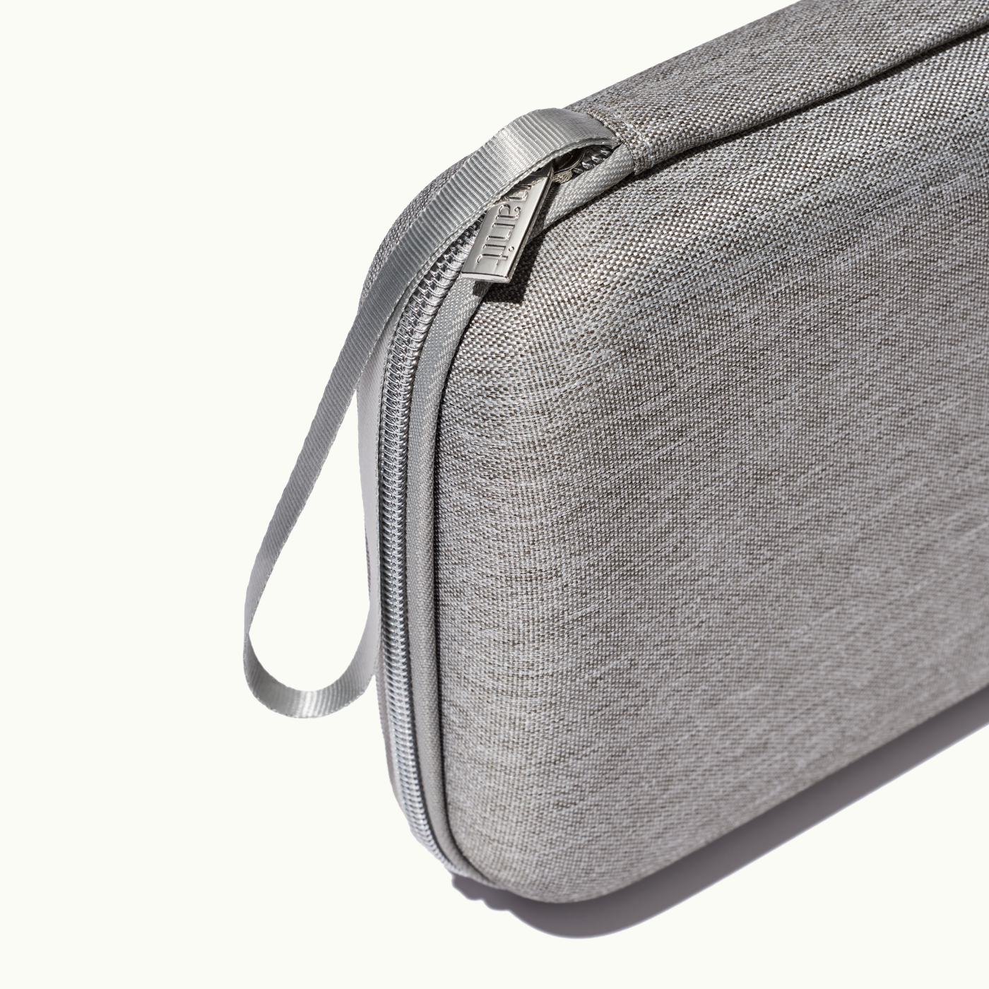 zoomed in picture of gray zipper and strap on gray travel case