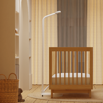 side view of nanit pro camera + floor stand in front of low crib where floor stand fits #mount_floor stand
