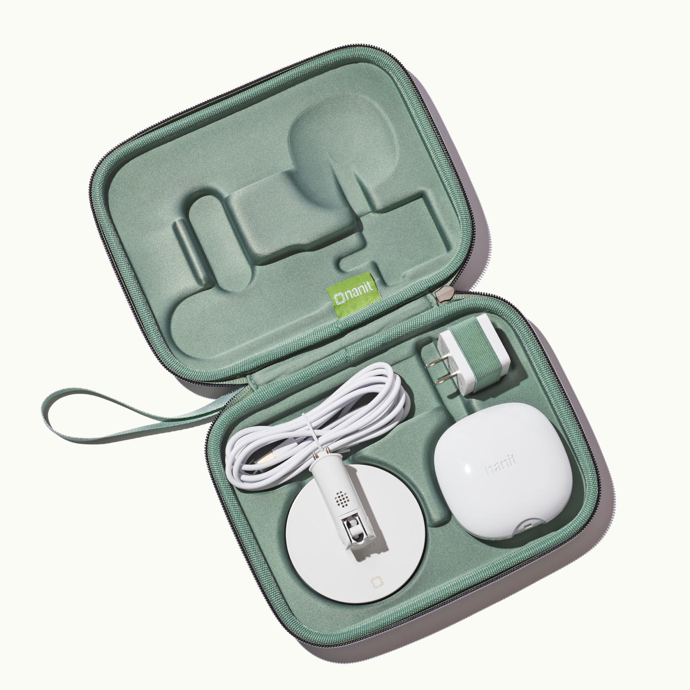 inside nanit travel case in green with nanit pro camera, flex stand, and power adapter 
